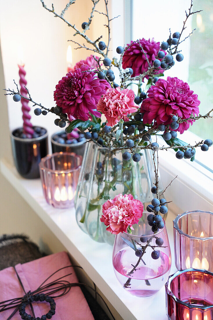 Rosa Nelken und Schlehenzweige und -beeren in Vase