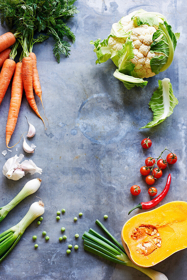 Frame of various vegetables on a grey stone background