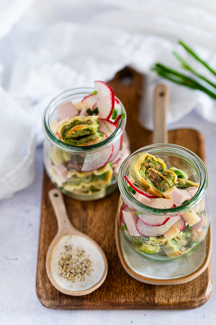 Maultaschen salad with sausage and radishes in a jar