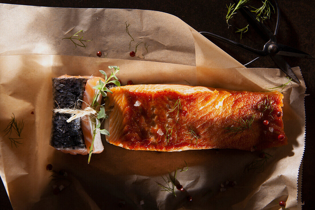 Roasted and raw salmon fillet with herbs and pink peppercorns