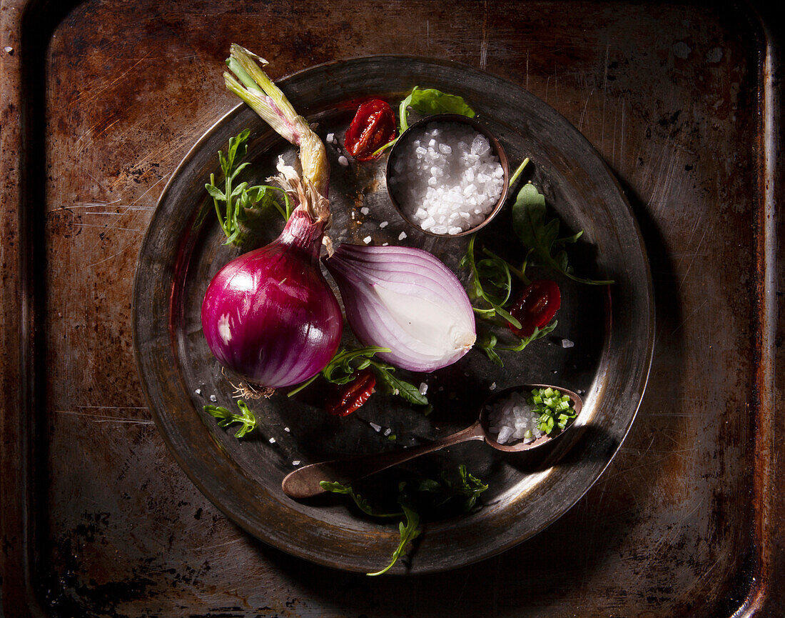 Sliced red onion with rocket, roasted cherry tomatoes and coarse salt