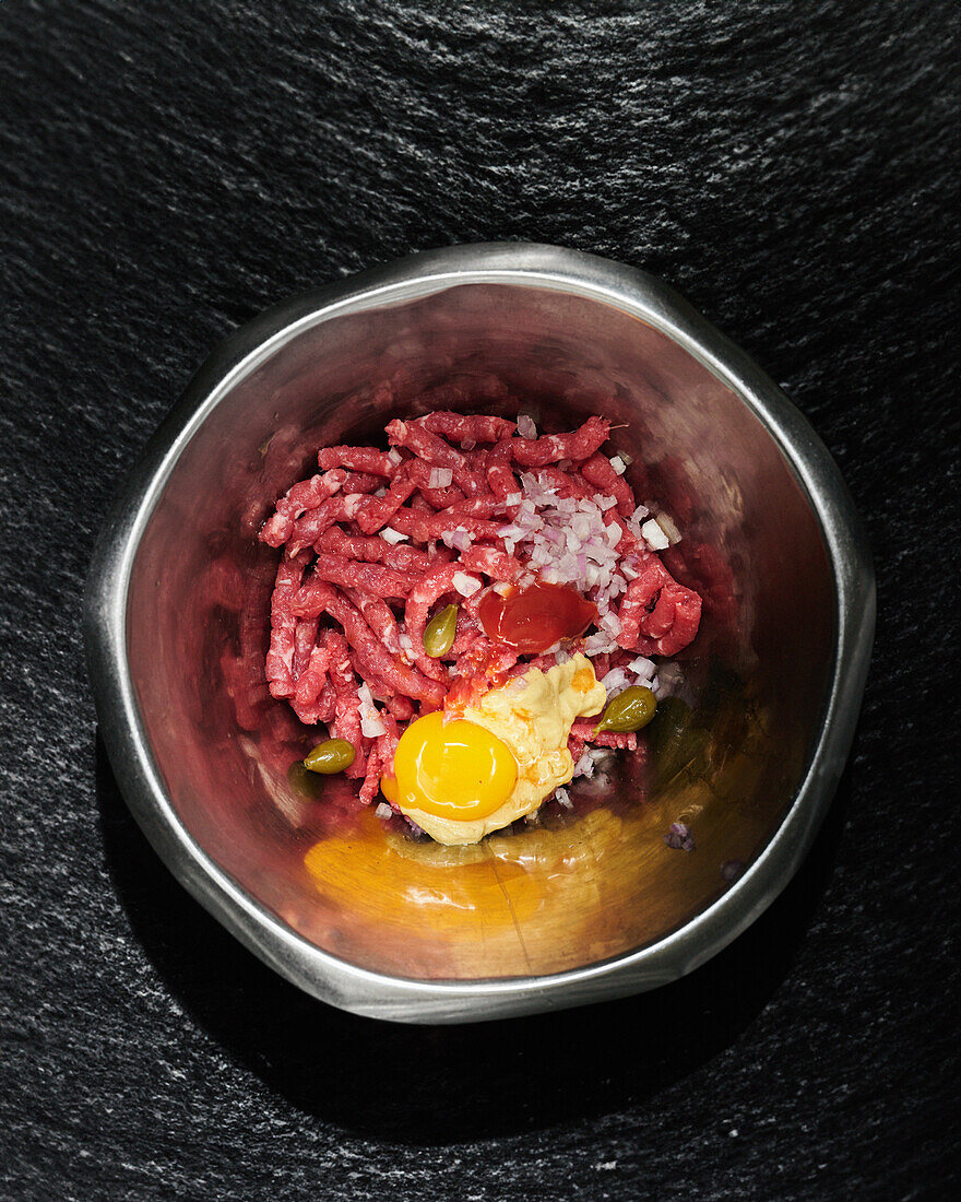 Raw beef tartare with onions, mustard, egg yolk and capers
