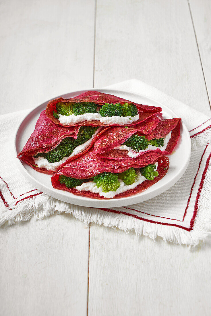 Beetroot crêpes filled with ricotta and broccoli