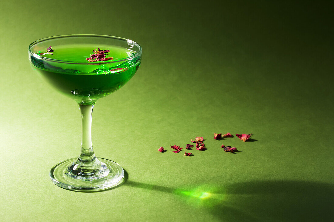 Green gin cocktail with dried rose petals