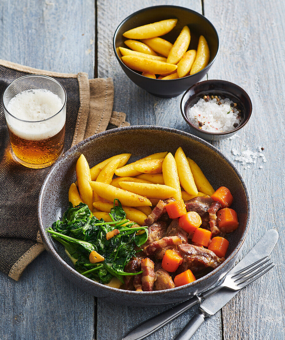 Turkey bites roasted in beer with carrots, spinach and potato noodles