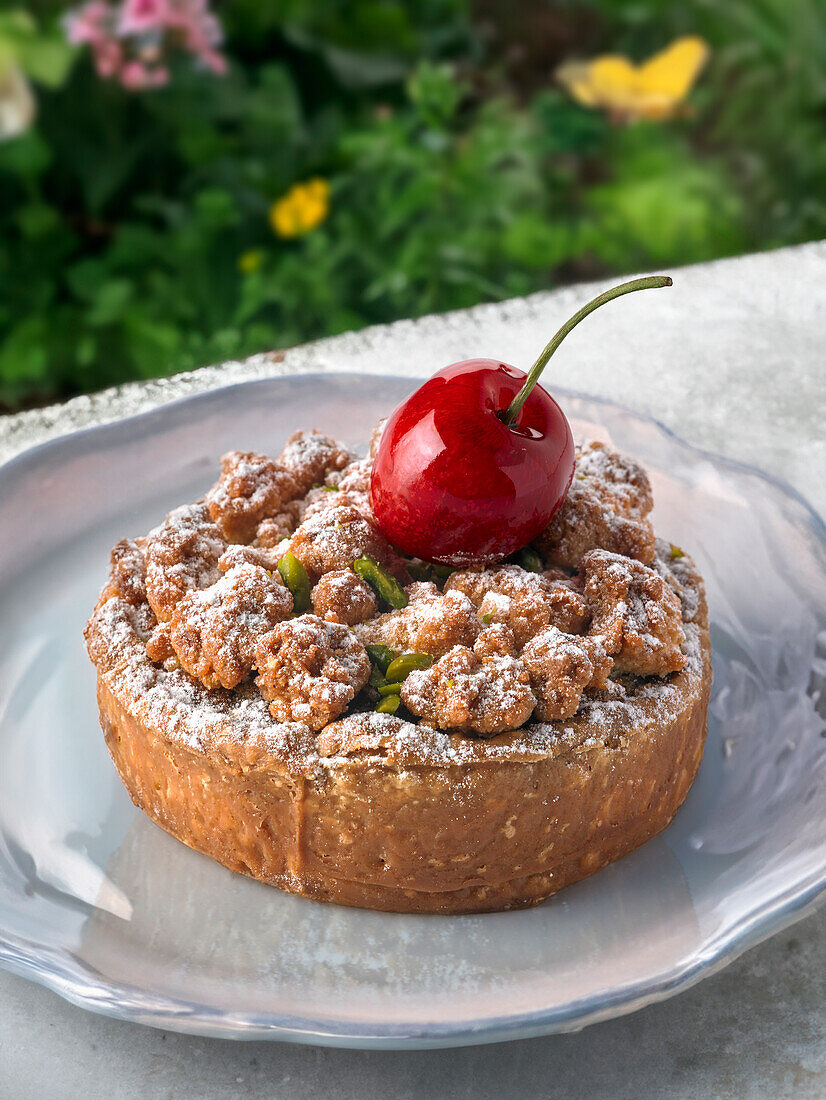 Tartelette mit knuspriger Streuseldecke und Kirsche