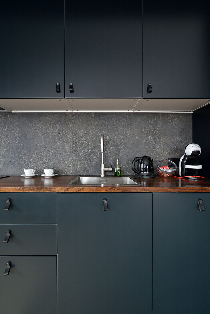 Modern kitchenette with dark cabinets