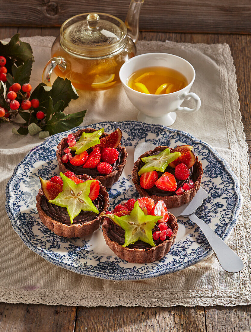 Chocolate tartelettes with strawberries, raspberries and carambola