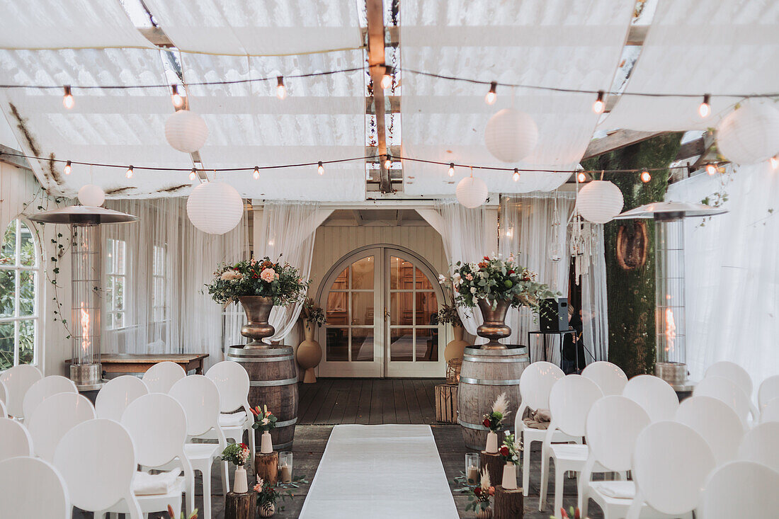 Decorated ceremony hall with lanterns and floral decorations for a wedding