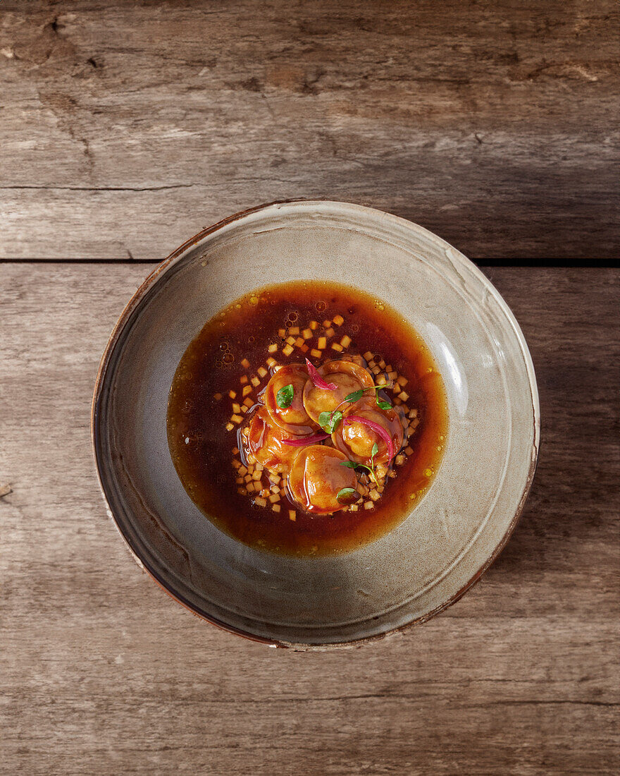 Ravioli mit Gänseleberfüllung, Selleriepüree und Tonkabohnen-Consommé