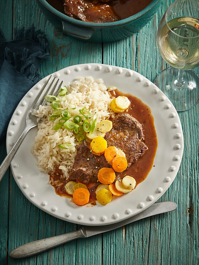 Braised beef with carrots and rice in a red wine sauce