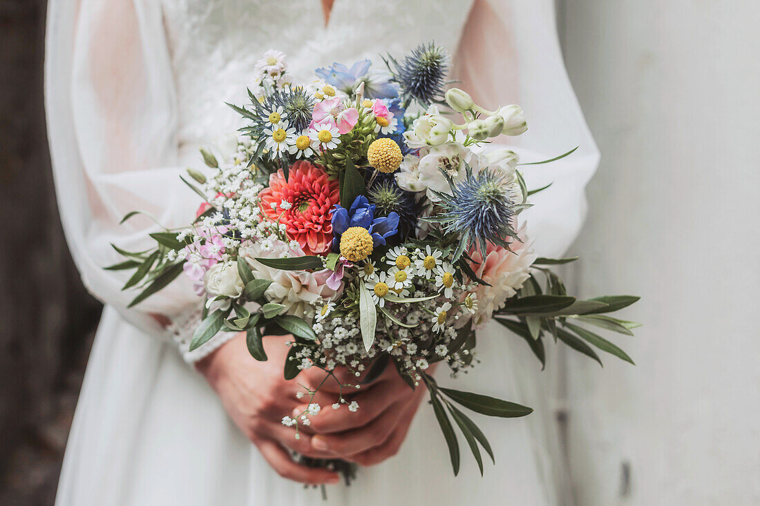 Bride holding varied bouquet of wildflowers