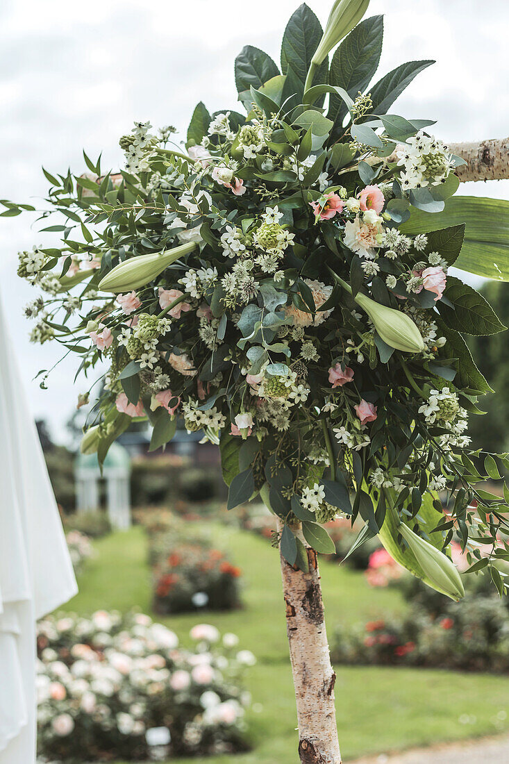 Blumenschmuck an Birkenstamm für eine Gartenhochzeit