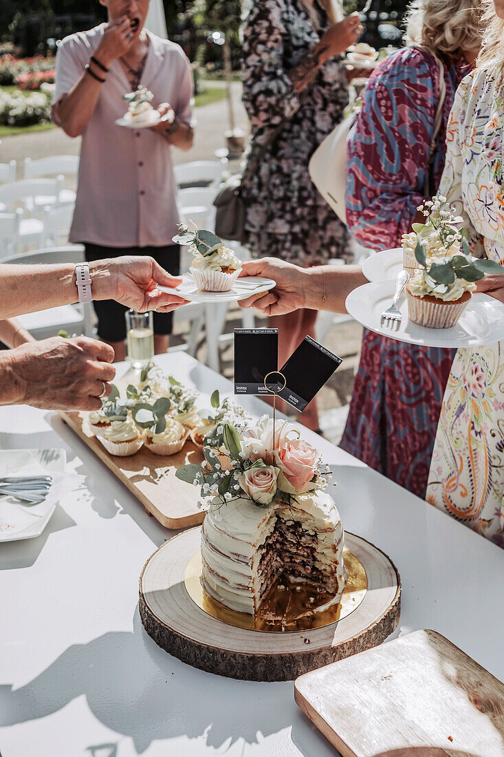 Wedding cake with floral decorations on outdoor banquet table