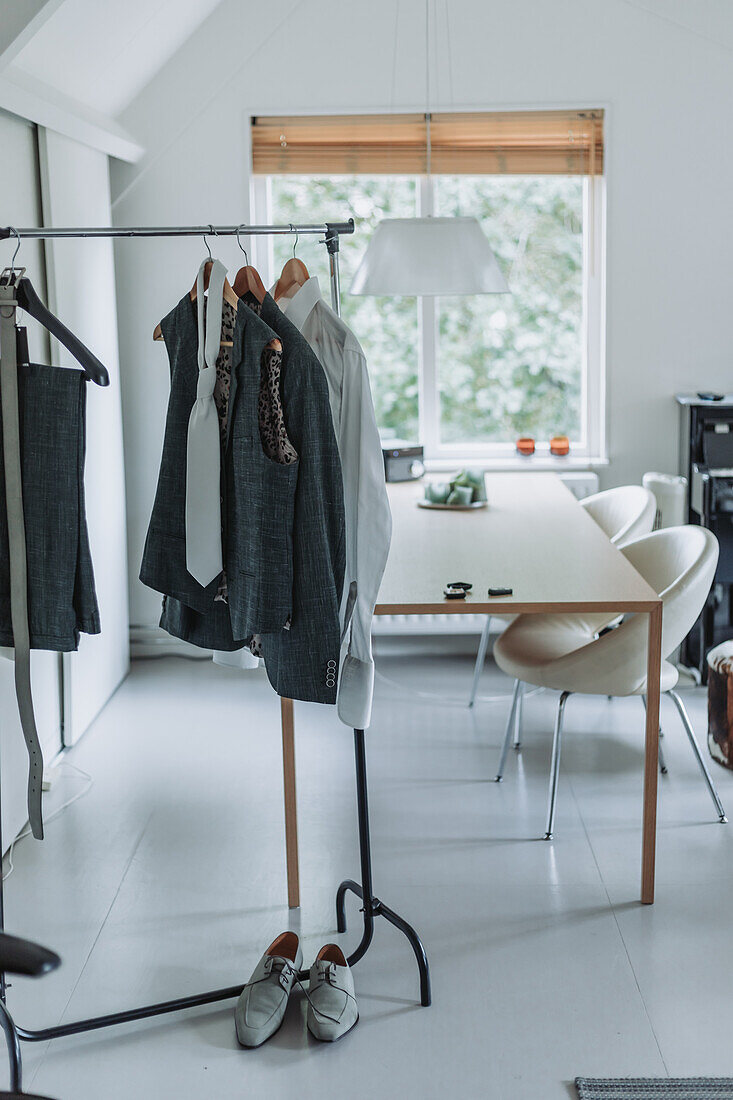 Clothes rail in a minimalist study with desk