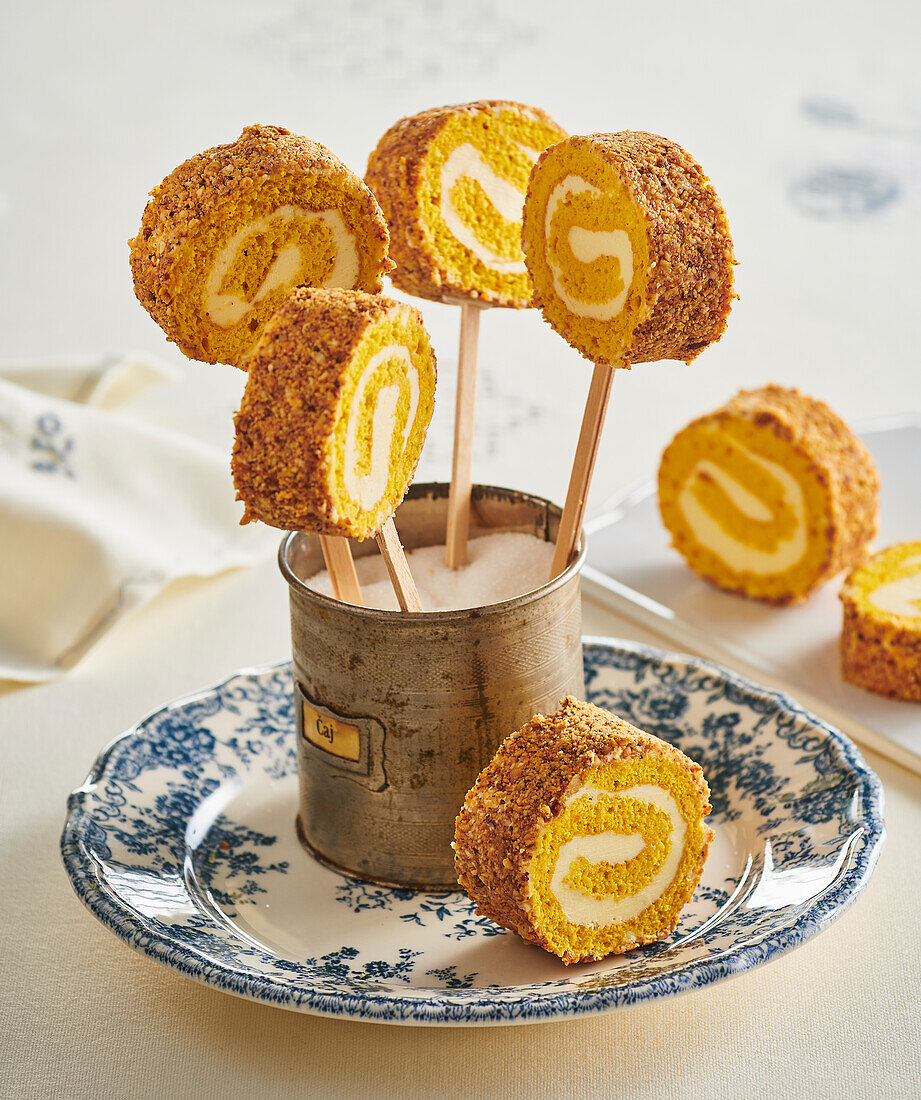 Pumpkin sponge roll on a stick with hazelnuts and cinnamon