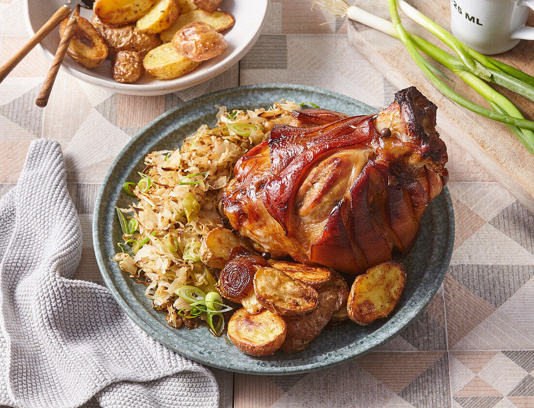 Gebratene Schweinshaxe mit Sauerkraut und Bratkartoffeln