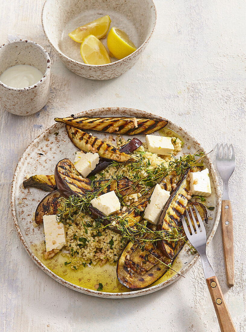 Grilled aubergines with feta and bulgur, fresh herbs and lemons