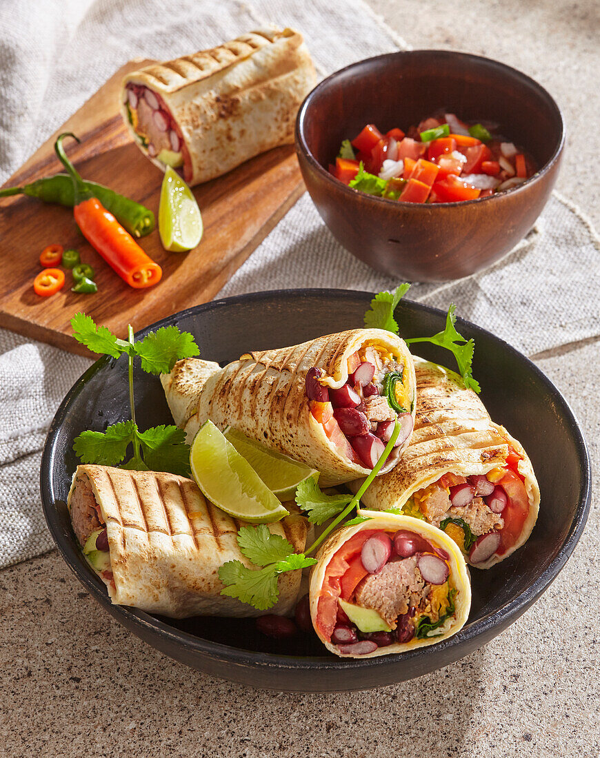 Burritos with pork, beans, avocado, tomatoes and coriander