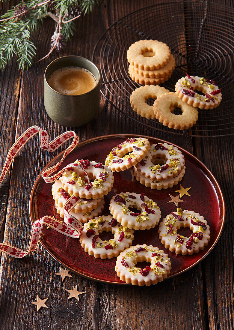 Ring-shaped biscuits with lemon icing, pistachios and cranberries