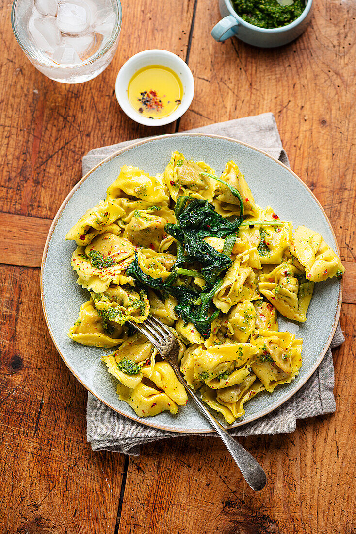 Wild garlic tortellini with spinach leaves and pesto