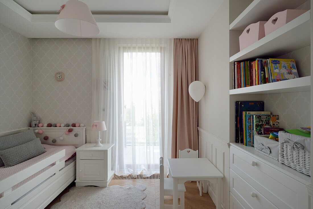 Brightly designed children's room with work area and built-in shelving