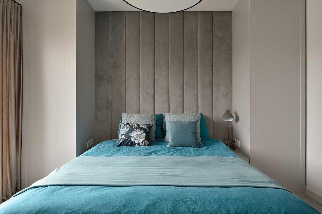 Modern bedroom with concrete wall and blue bed linen