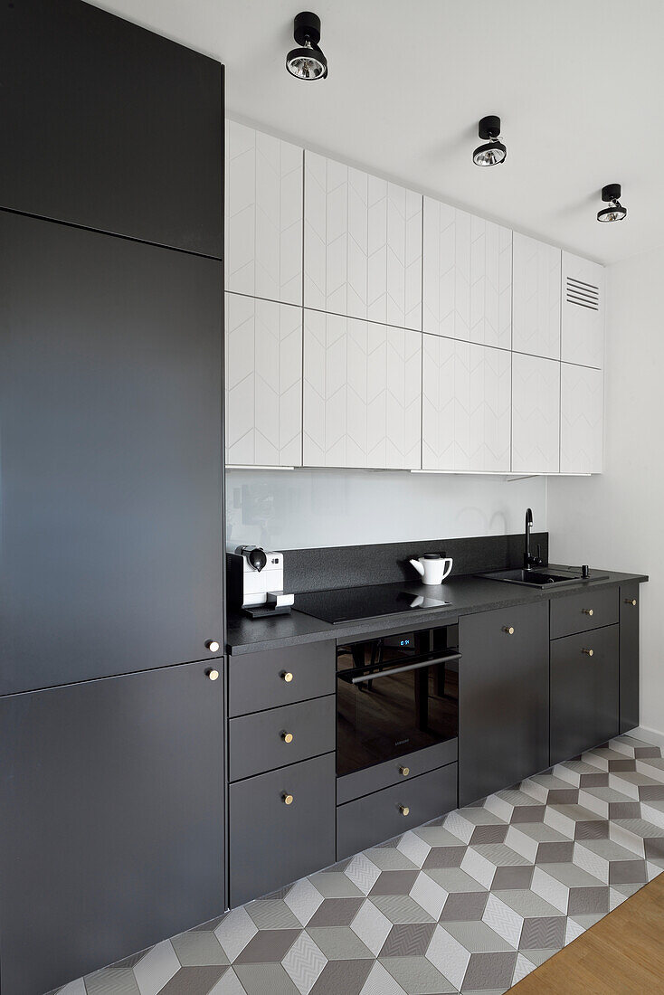 Kitchen in black and white with geometric tiled floor