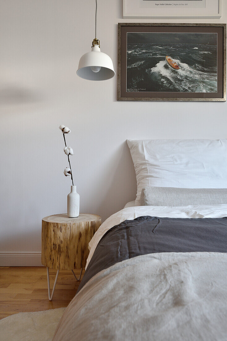 Wooden bedside table and maritime wall art in the bedroom