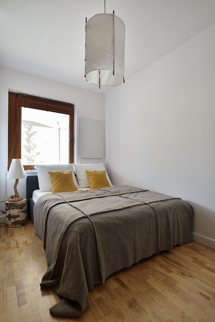 Simple bedroom with brown throw and mustard yellow pillows