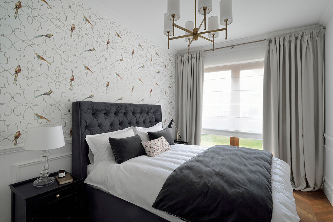 Bedroom with upholstered bed and floral wallpaper pattern