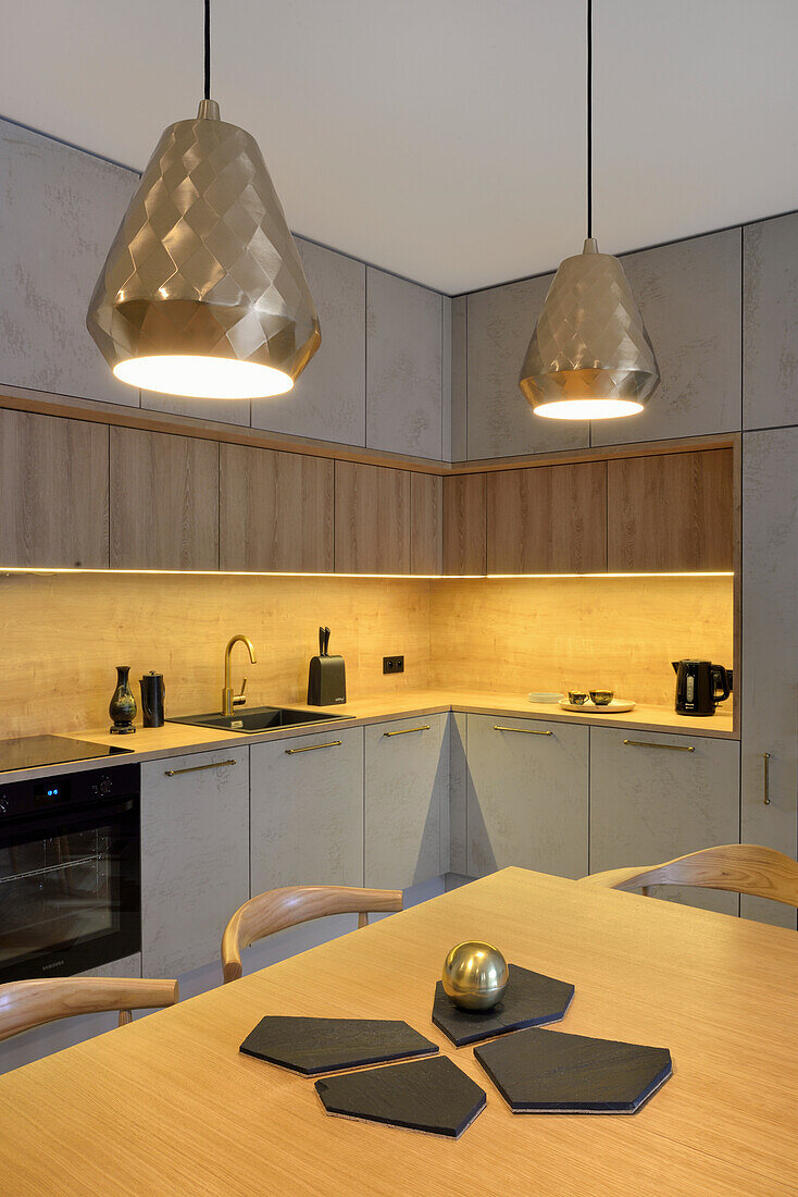 Modern kitchen unit with wood and concrete look and geometric pendant lights