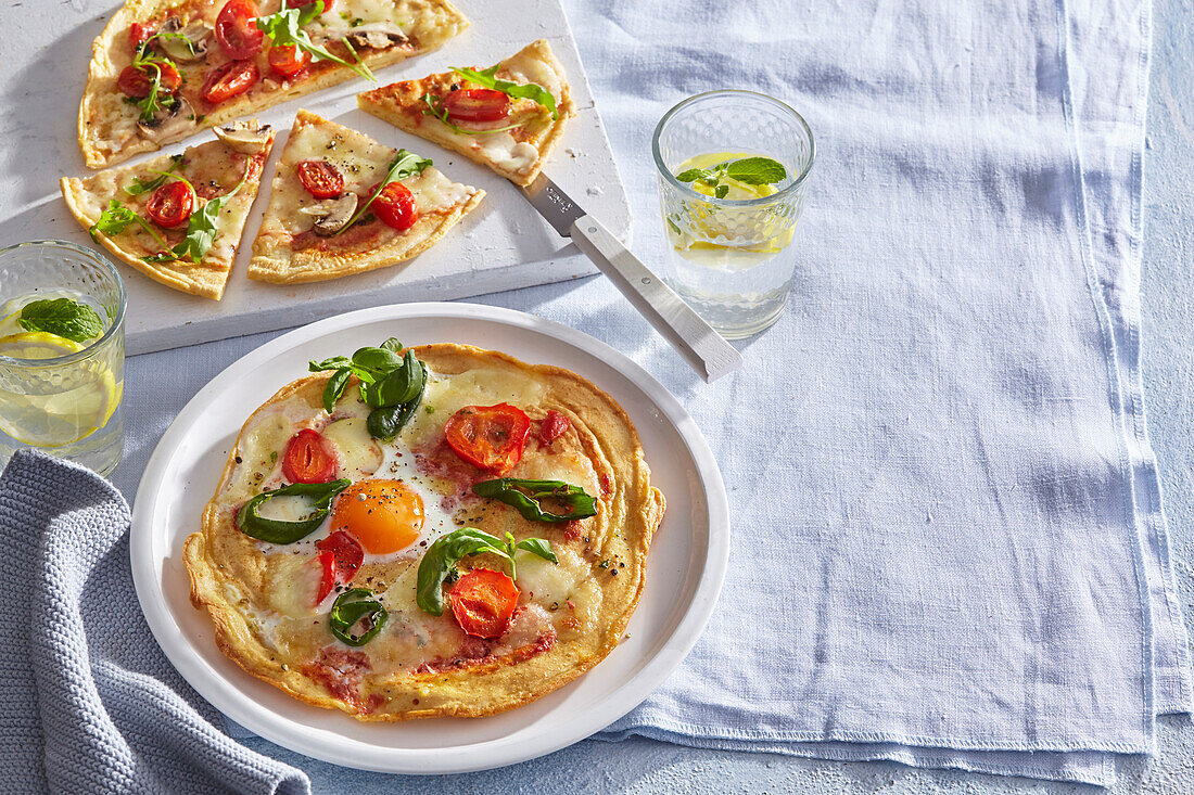 Pizza mit Tomaten, Ei, Rucola und Mozzarella