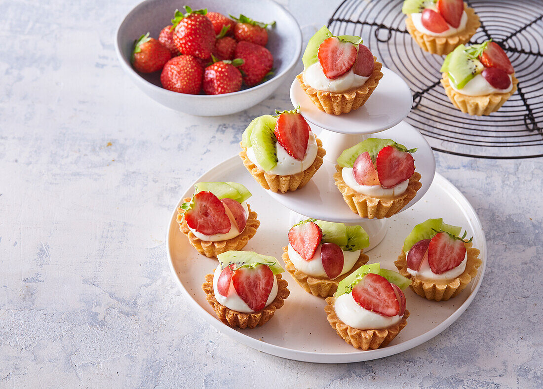 Mini-Obsttörtchen mit Sahne, Kiwi, Erdbeeren und Trauben