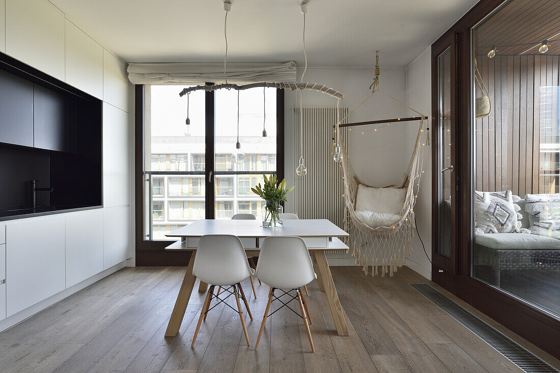 Modern eat-in kitchen with white table, chairs, DIY pendant light and hanging chair