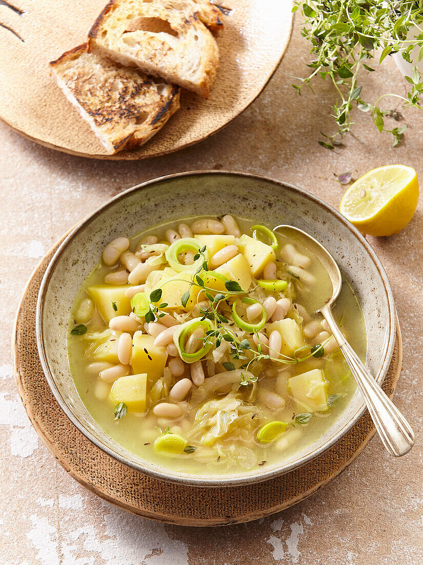 White cabbage soup with beans, potatoes, leek and thyme