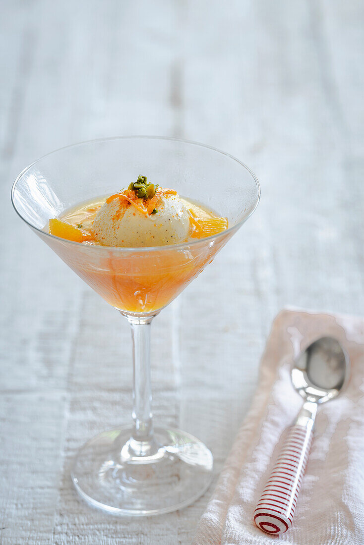 Vanilla ice cream on orange compote with chopped pistachios