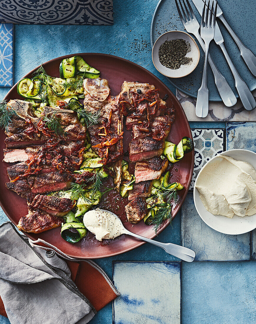 Gegrilltes T-Bone-Steak mit karamellisierten Zwiebeln, Zucchini und Dip