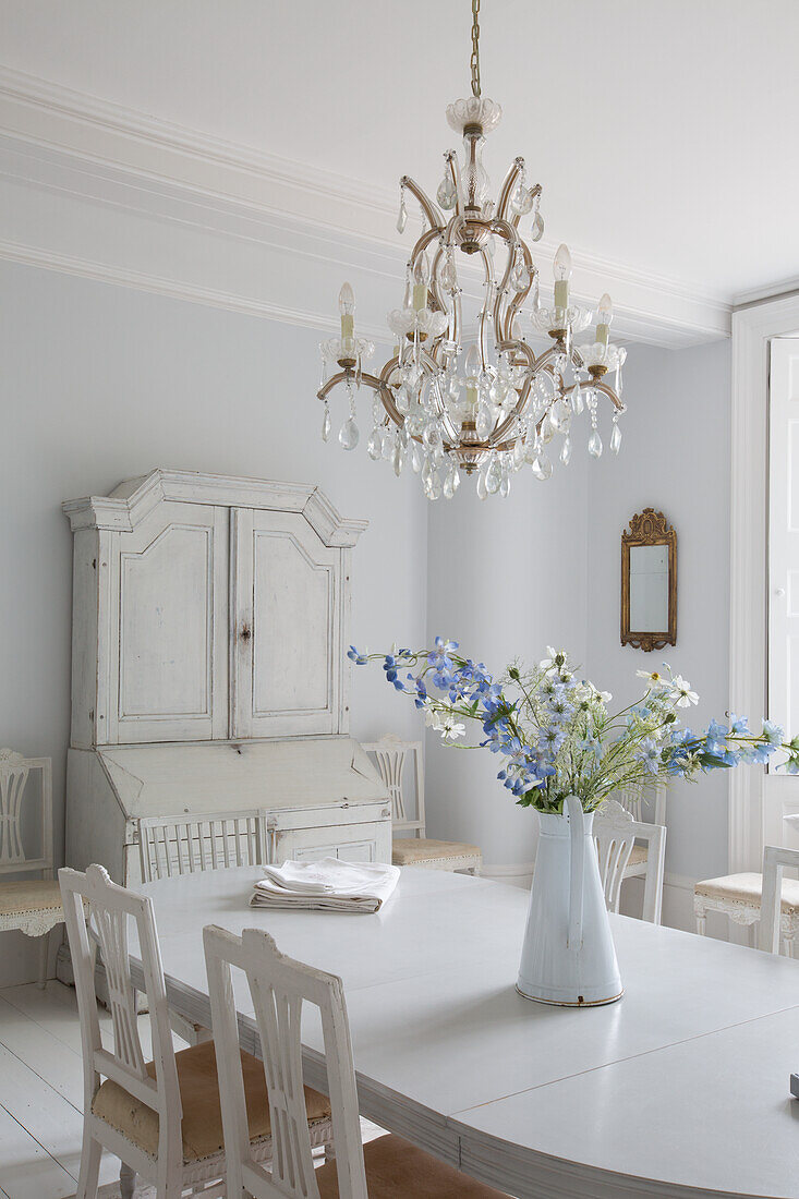 Country-style dining room with chandelier and white furniture