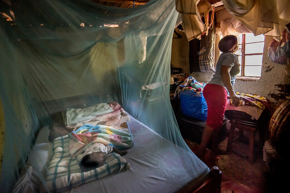Child sleeping in mosquito net, Kenya