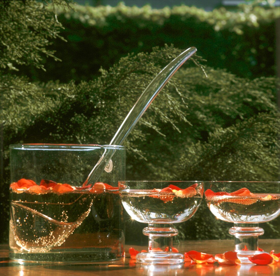 Rose-Sekt punch in glasses & glass bowl on table outdoors