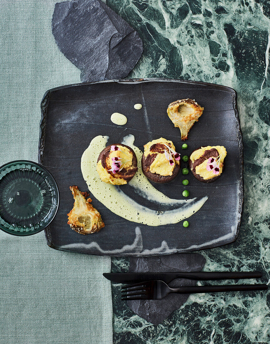 Gefüllte Champignons mit Oliven-Polenta-Kern und panierten Artischocken