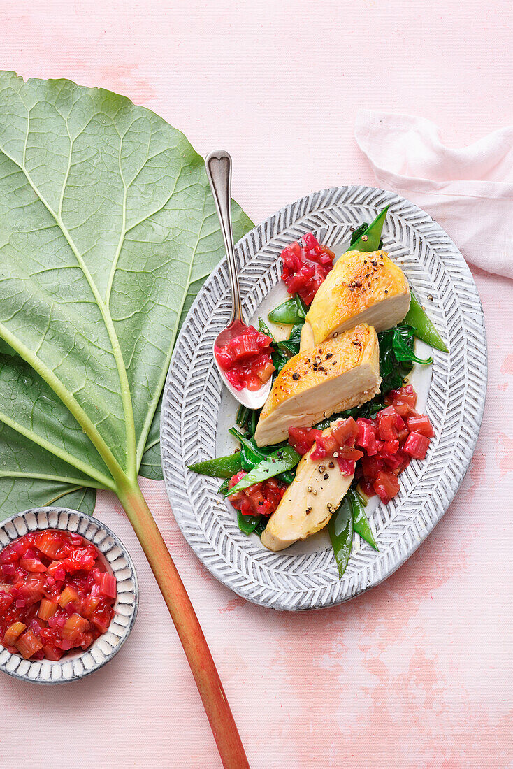 Chicken breast with sweet and tangy rhubarb jam on sugar snap peas and spinach vegetables