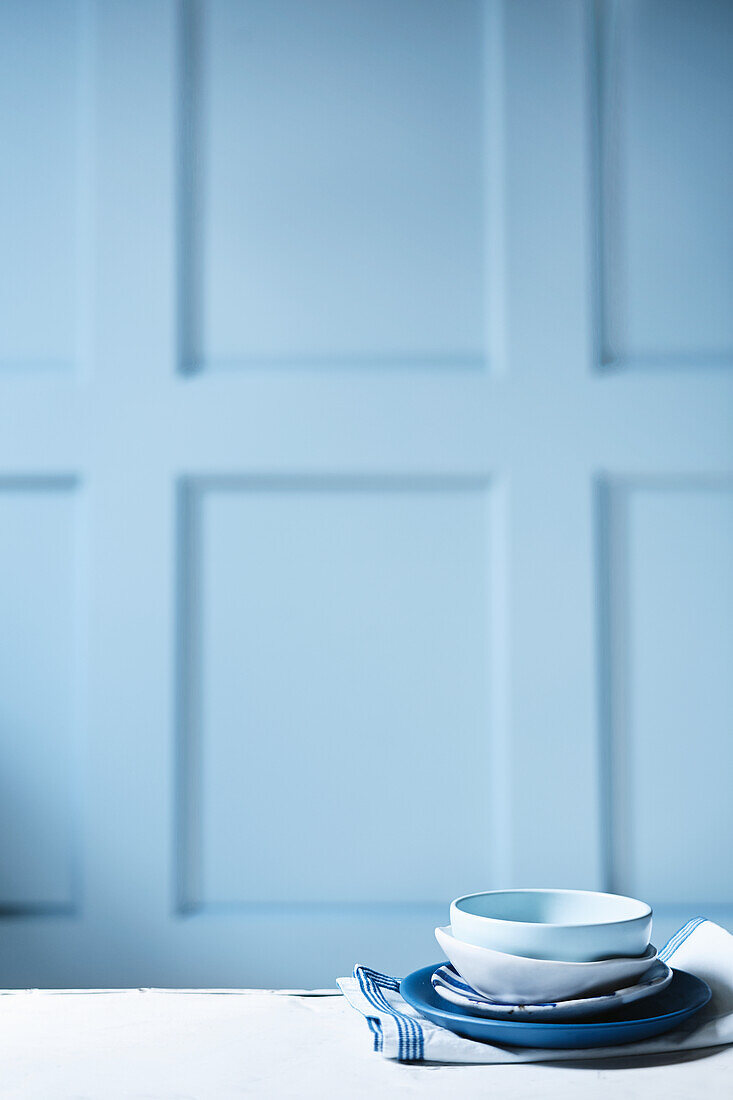 Porcelain plates and bowls against a light blue background