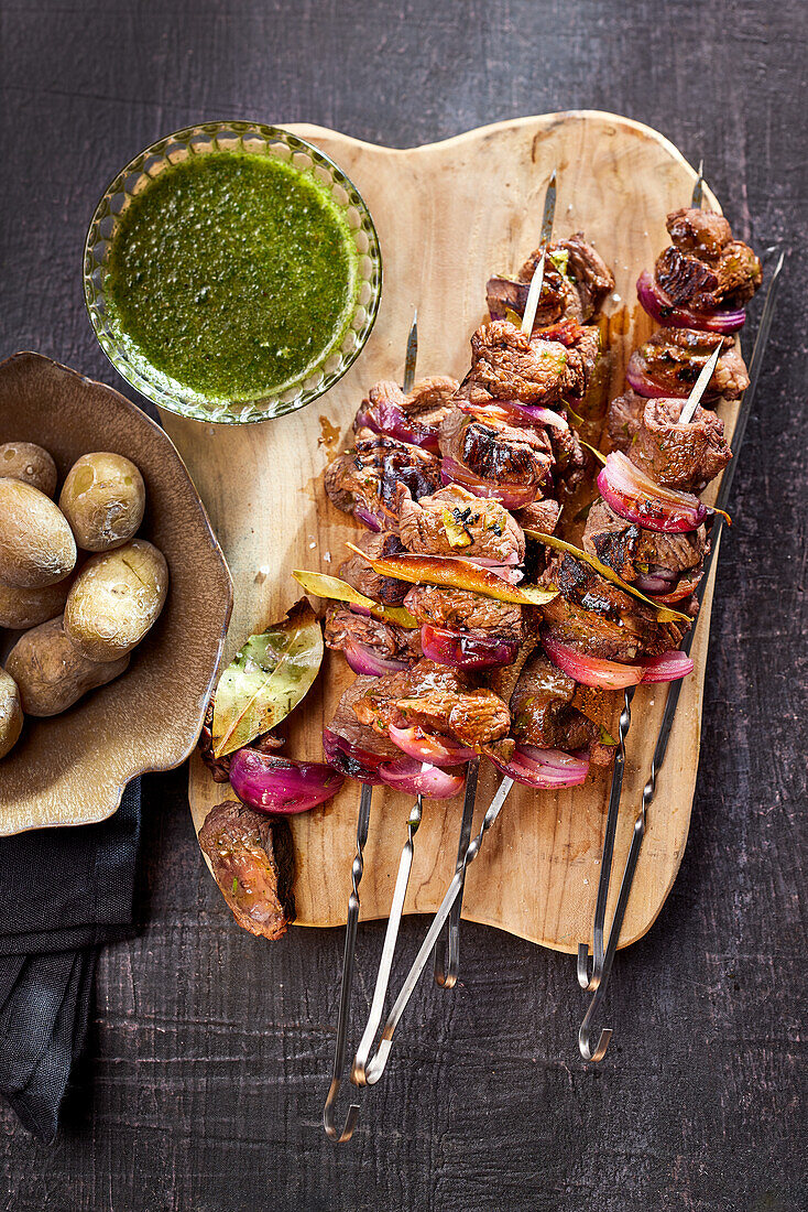 Portuguese beef fillet skewers with onions, served with potatoes and herb sauce