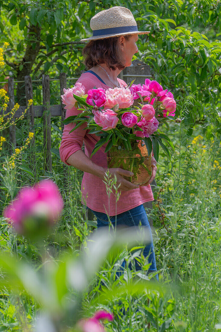 Woman with peonies in the garden