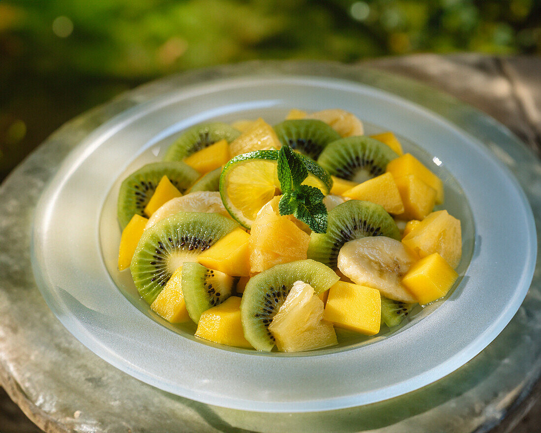 Fruit salad with banana, mango, kiwi, lime juice and mint