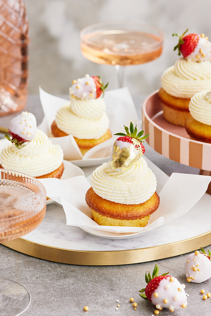 Buttermilk cupcakes with glazed strawberries and gold leaf