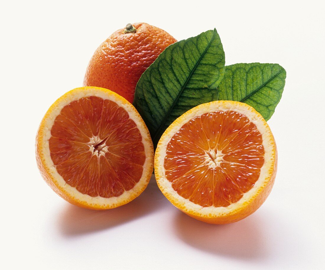 Blood orange: two halves in front of whole orange & leaves