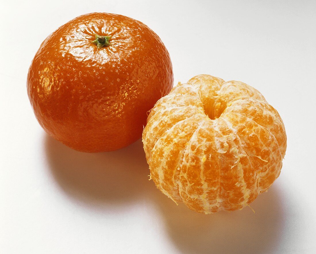 Eine Tangerine mit & eine ohne Schale
